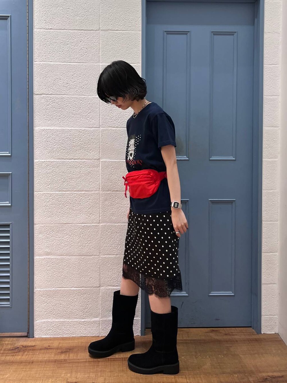 ブラック系のブーツ、レッド系のボディバッグ/ウエストポーチ、ブルー系のTシャツ/カットソーを着用したレディースの春コーディネートの2枚目の写真