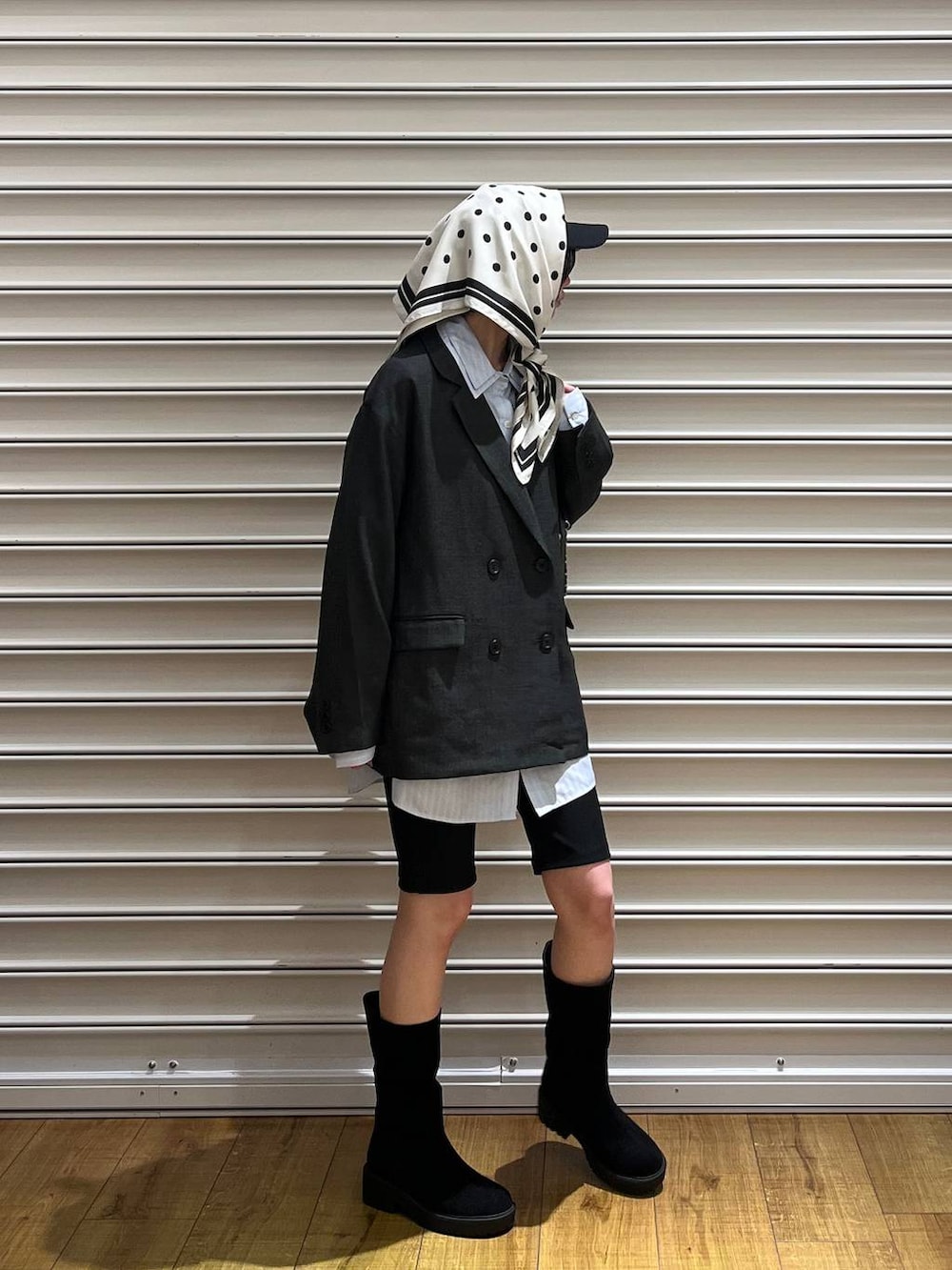 グレー系のテーラードジャケット、ブラック系のブーツ、ブラック系のショルダーバッグを着用したレディースの冬コーディネートの3枚目の写真