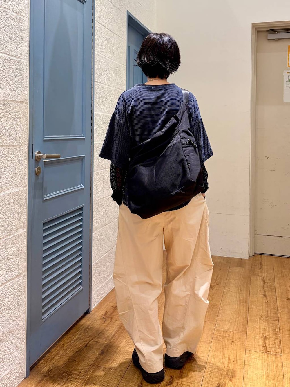 ブラック系のショルダーバッグ、ベージュ系のその他パンツ、グリーン系のTシャツ/カットソーを着用したレディースの夏コーディネートの3枚目の写真