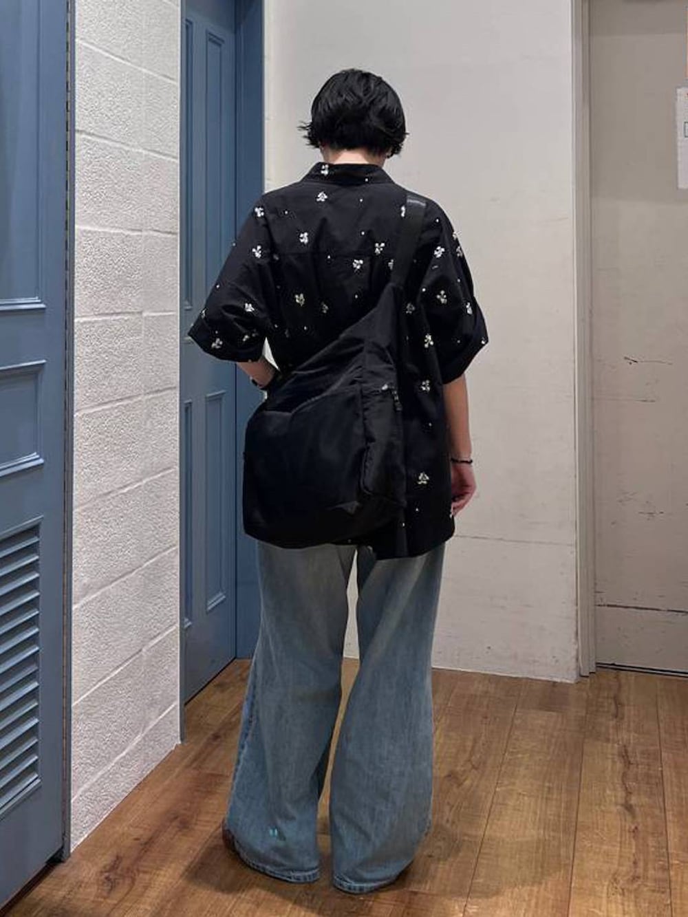 ブラック系のショルダーバッグ、ブルー系のデニムパンツ、ブラック系のシャツ/ブラウスを着用したレディースの夏コーディネートの2枚目の写真