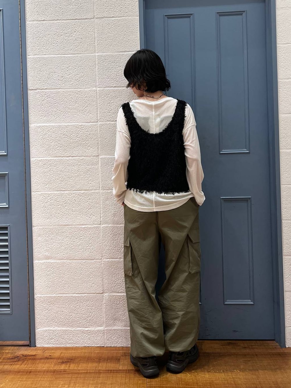 ホワイト系のTシャツ/カットソー、グリーン系のカーゴパンツ、ブラック系のベストを着用したレディースの春コーディネートの3枚目の写真