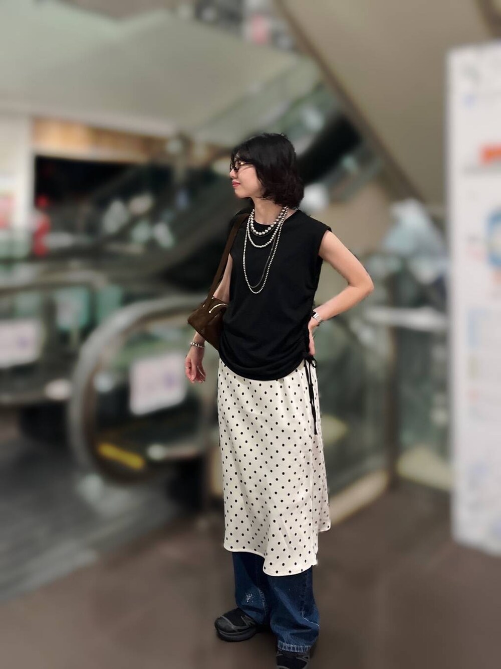 ホワイト系のスカート、ブルー系のデニムパンツ、ホワイト系のTシャツ/カットソーを着用したレディースの夏コーディネートの2枚目の写真