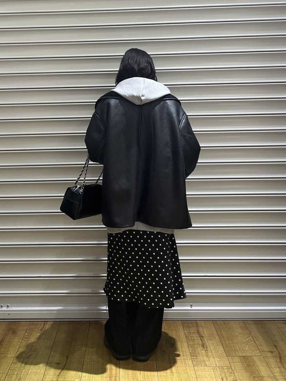 ブラック系のスカート、グレー系のパーカー、ブラック系のその他パンツを着用したレディースの冬コーディネートの2枚目の写真