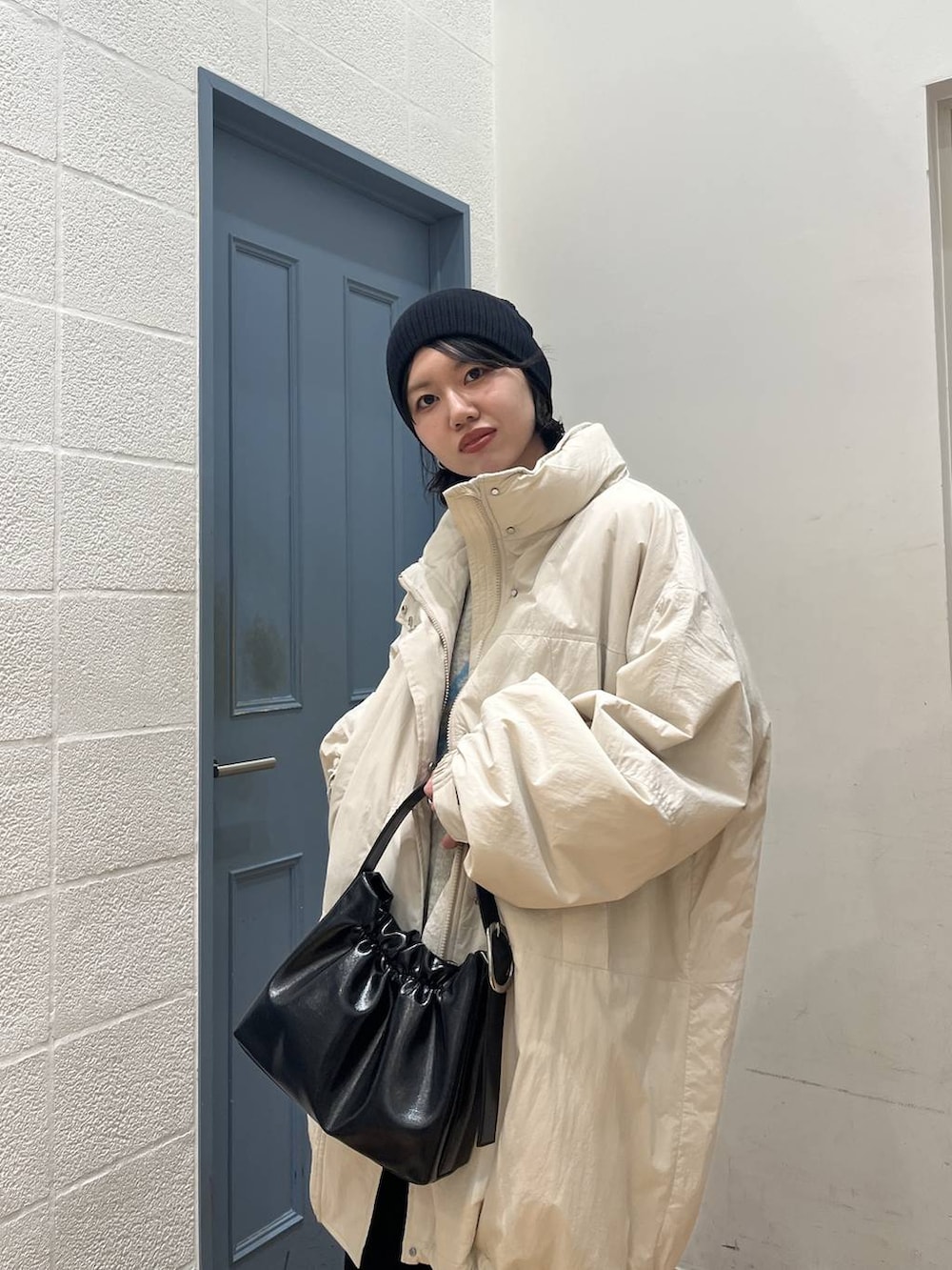 ホワイト系のブルゾン、ブラック系のサンダル、ブラック系のスカートを着用したレディースの冬コーディネートの4枚目の写真