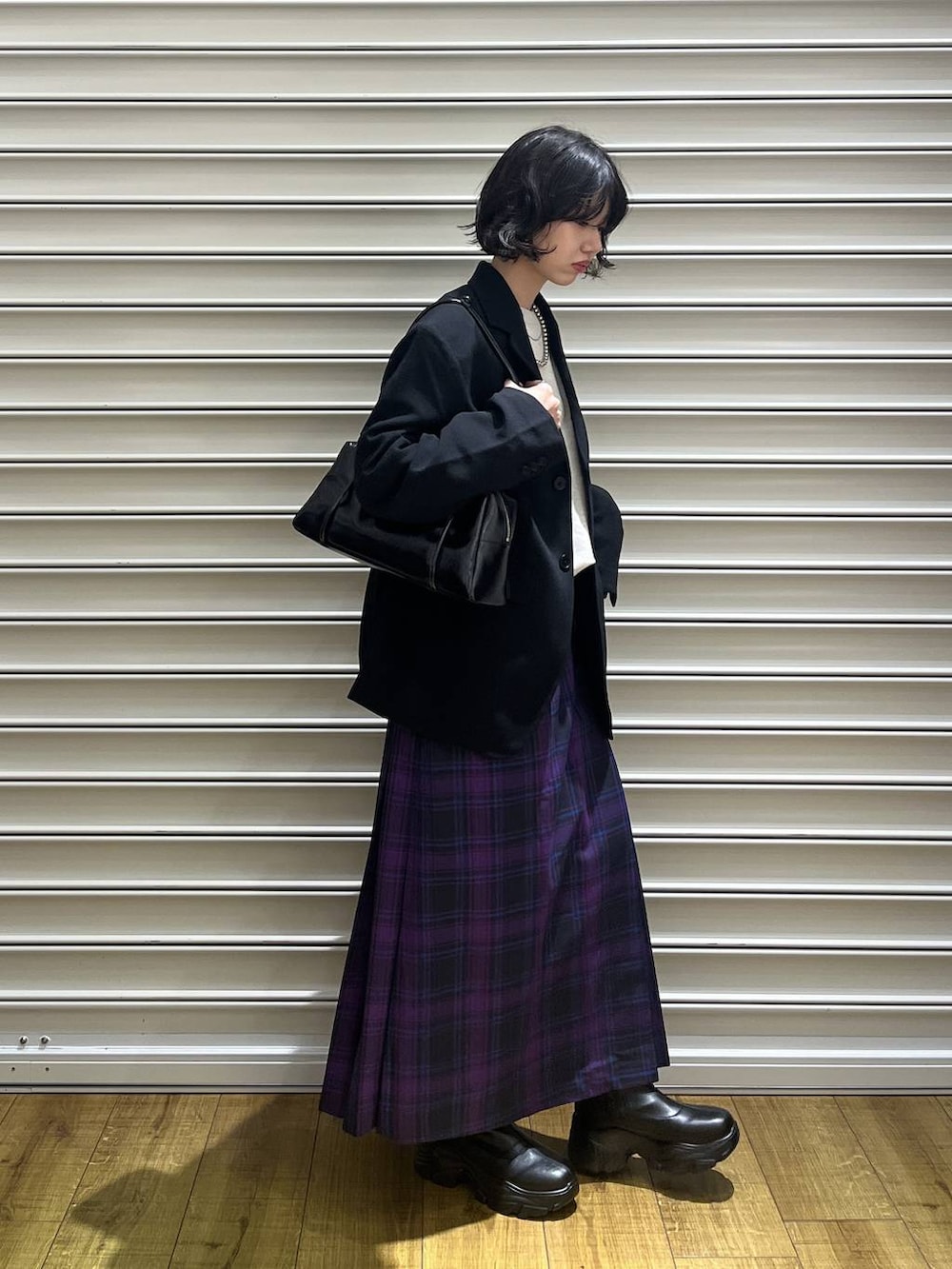 ブラック系のブーツ、ブラック系のテーラードジャケット、パープル系のスカートを着用したレディースの冬コーディネートの3枚目の写真