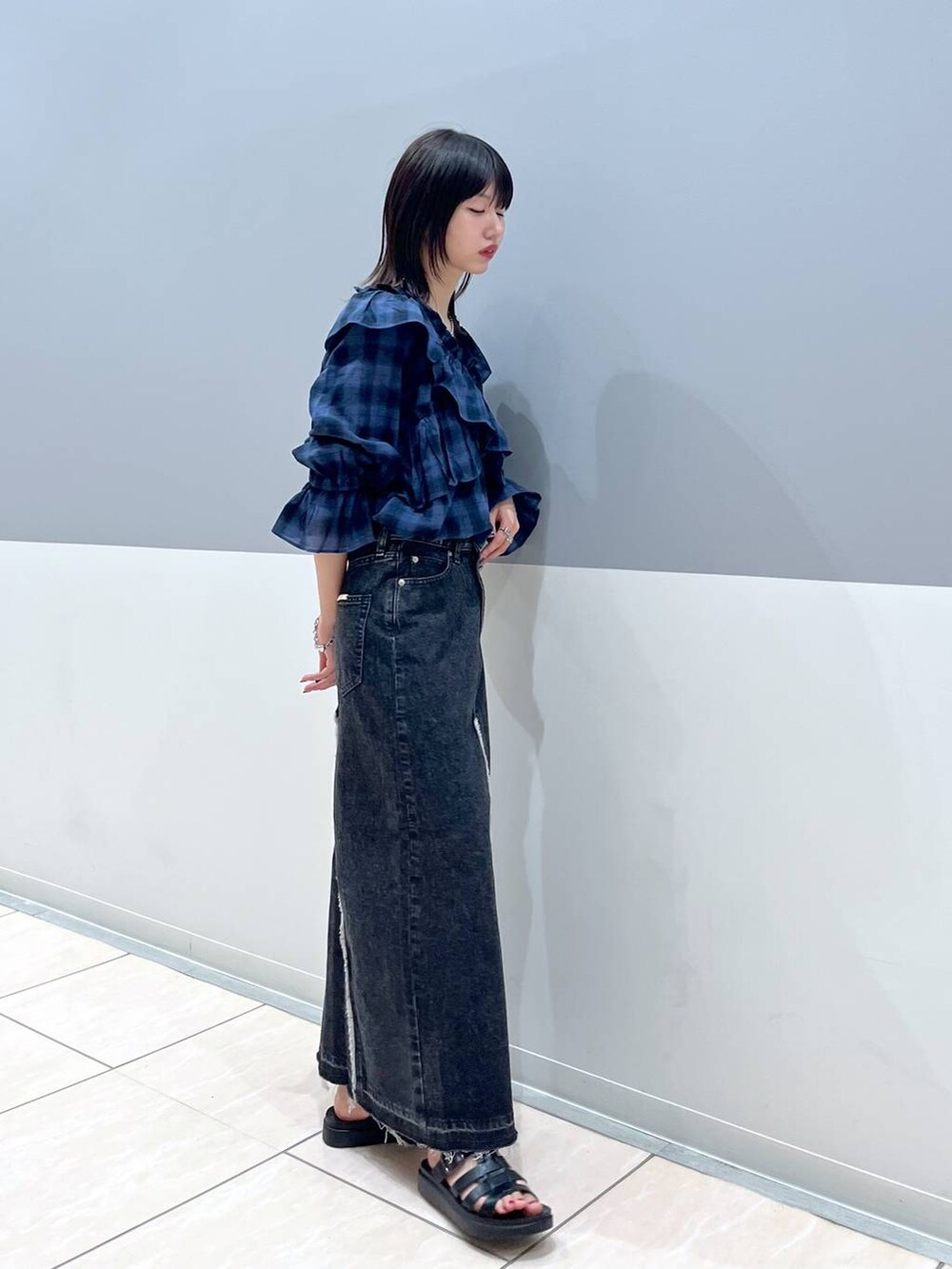 ブラック系のスニーカー、ブルー系のシャツ/ブラウス、ブラック系のスカートを着用したレディースの夏コーディネートの2枚目の写真