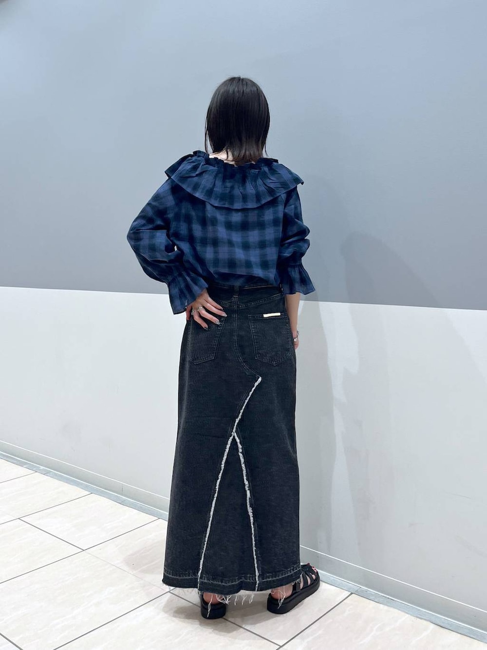 ブラック系のスニーカー、ブルー系のシャツ/ブラウス、ブラック系のスカートを着用したレディースの夏コーディネートの3枚目の写真
