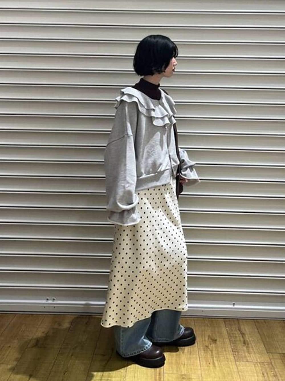 ブラウン系のショルダーバッグ、ホワイト系のスカート、ブラウン系のニット/セーターを着用したレディースの冬コーディネートの2枚目の写真