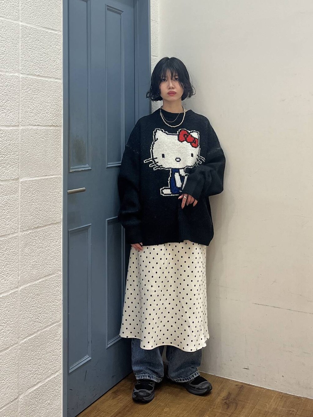 ホワイト系のスカート、ブルー系のデニムパンツ、ブラック系のニット/セーターを着用したレディースの秋コーディネートの2枚目の写真