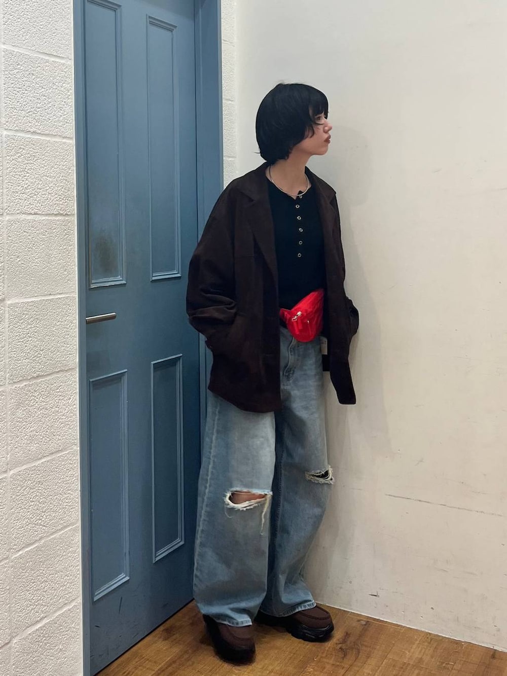 ブラック系のニット/セーター、ブルー系のデニムパンツ、ブラウン系のローファーを着用したレディースの春コーディネートの2枚目の写真