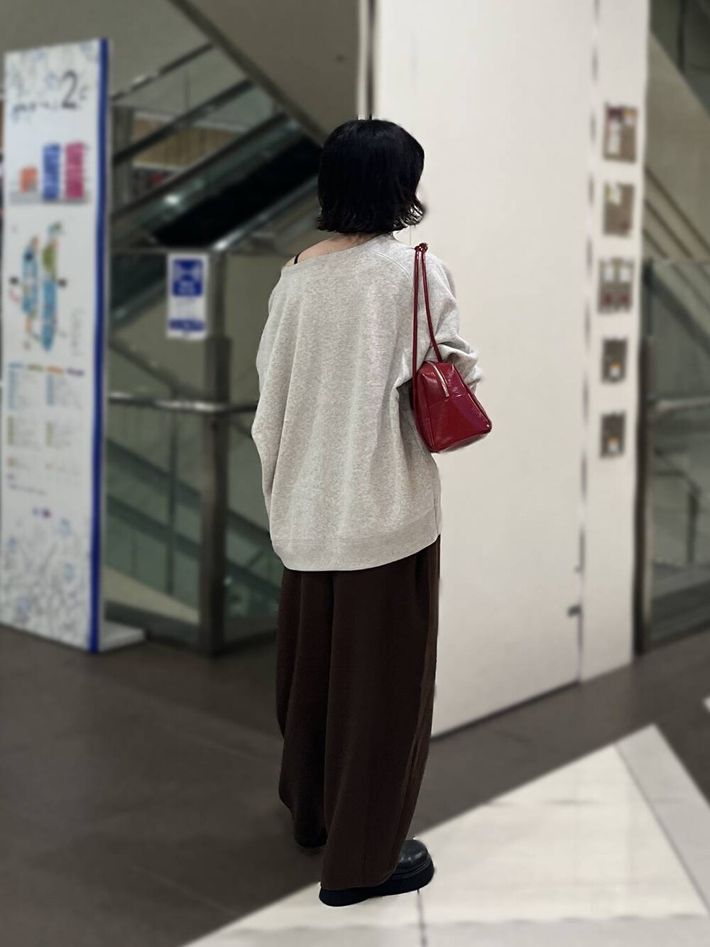 ブラック系のサンダル、グレー系のニット/セーター、レッド系のボストンバッグを着用したレディースの秋コーディネートの3枚目の写真