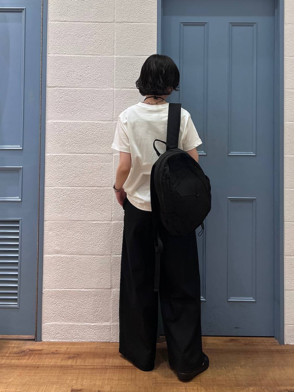 ブラック系のその他パンツ、ブラック系のサンダル、ホワイト系のTシャツ/カットソーを着用したレディースの春コーディネートの2枚目の写真