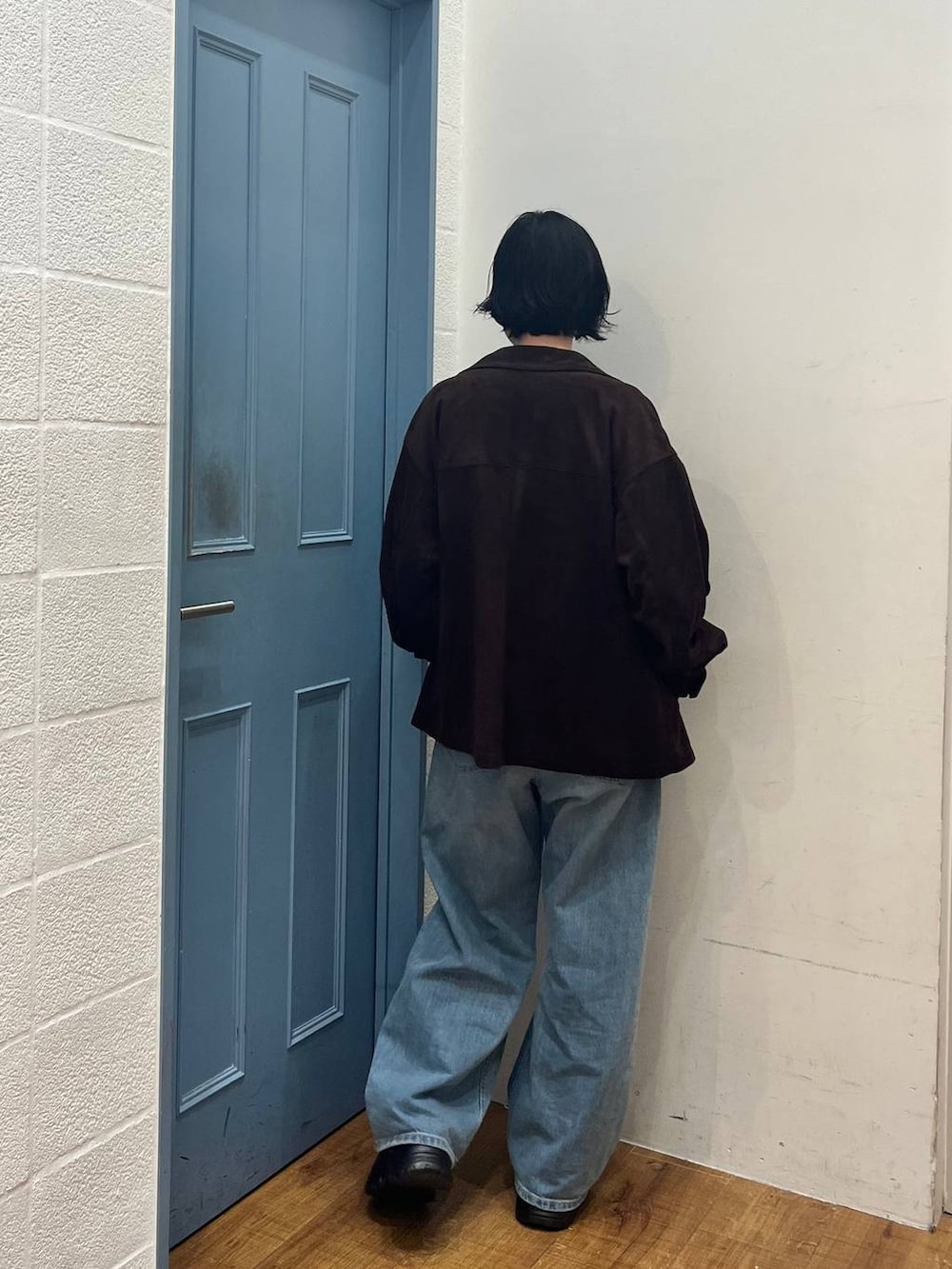 ブラック系のニット/セーター、ブルー系のデニムパンツ、ブラウン系のローファーを着用したレディースの春コーディネートの3枚目の写真