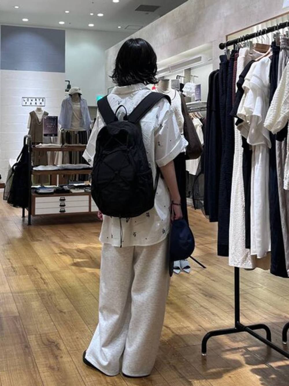 グレー系のスウェットパンツ、ブラウン系のサンダル、ブラック系のキャミソールを着用したレディースの夏コーディネートの3枚目の写真