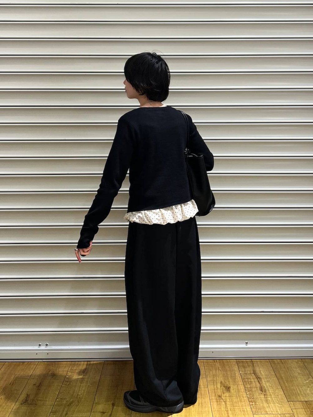 ブラック系のその他パンツ、ブラック系のトートバッグ、ホワイト系のTシャツ/カットソーを着用したレディースの春コーディネートの3枚目の写真