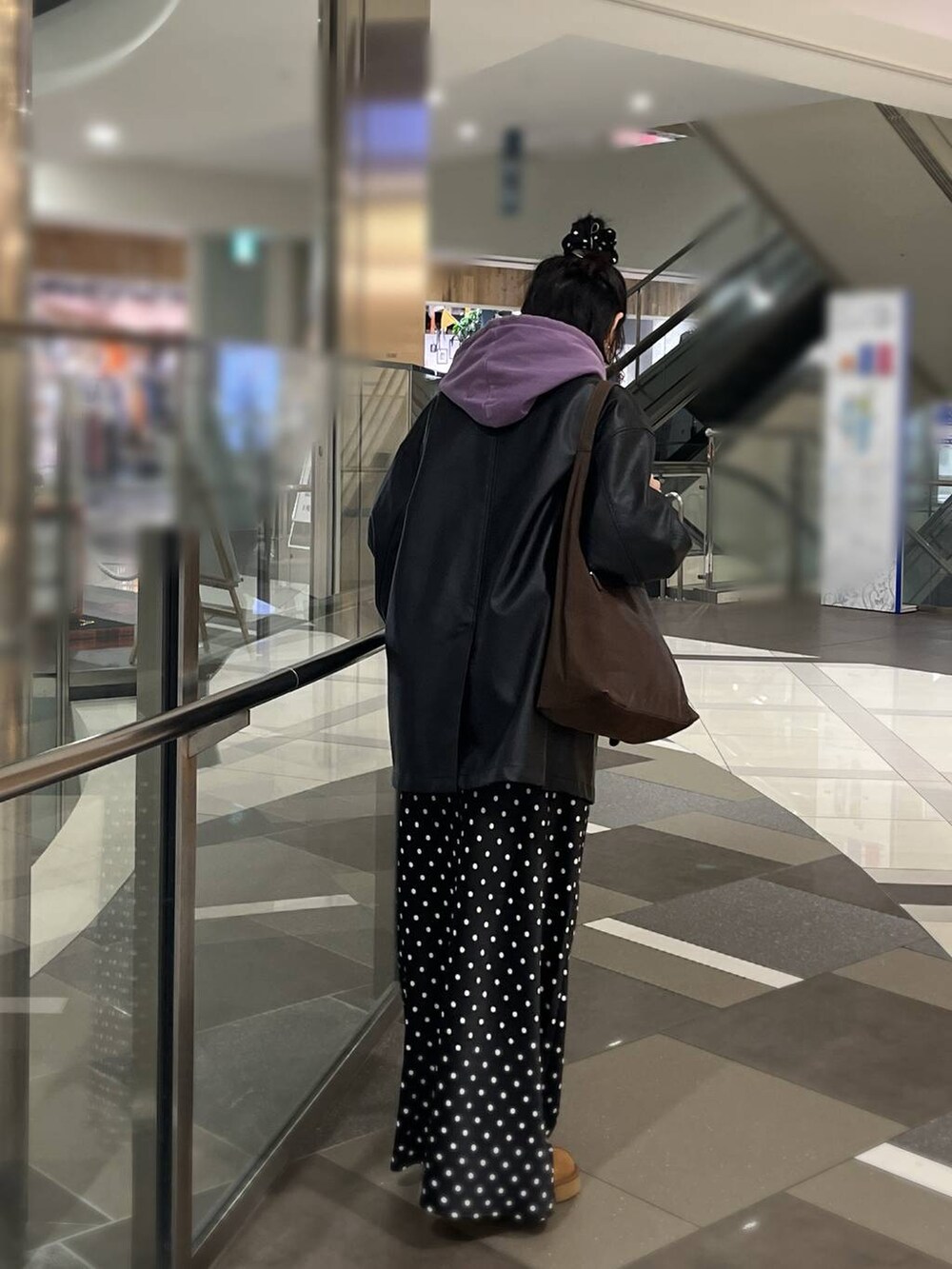 ブラウン系のショルダーバッグ、ブラック系のスカート、パープル系のパーカーを着用したレディースの秋コーディネートの3枚目の写真