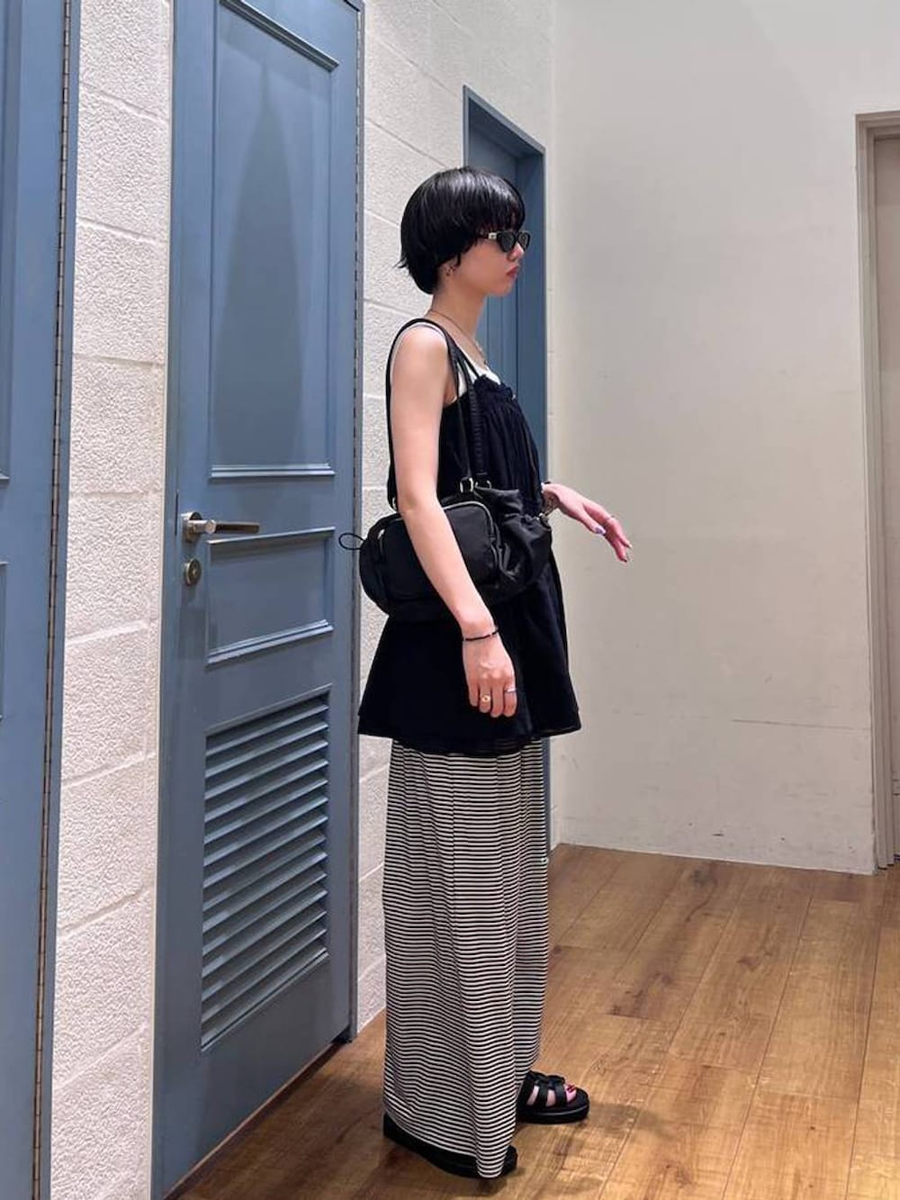 ブラック系のキャミソール、ホワイト系のその他パンツ、ブラック系のサンダルを着用したレディースの夏コーディネートの2枚目の写真