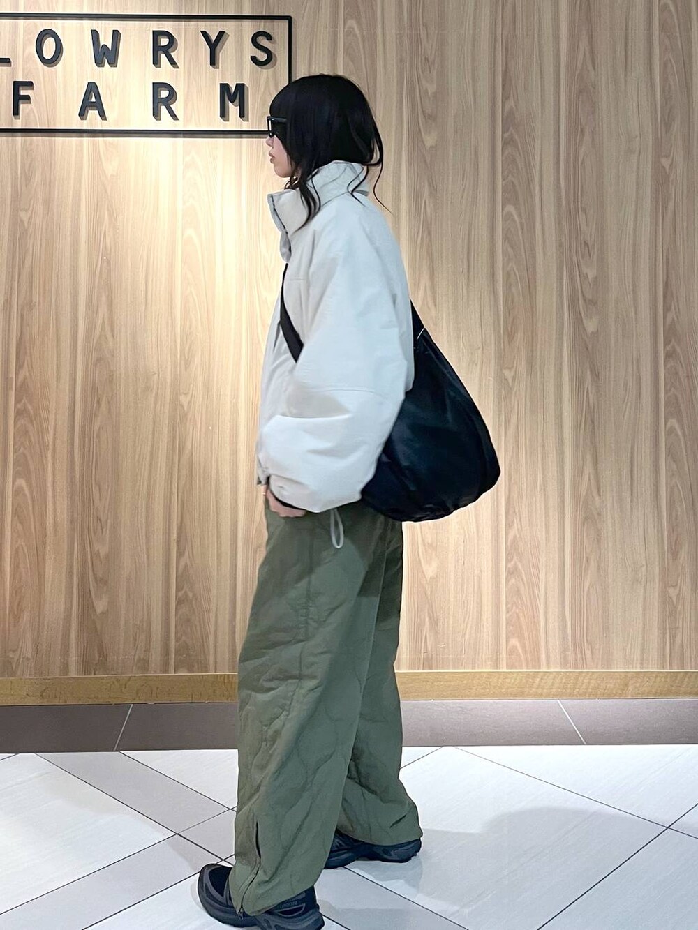 グリーン系のその他パンツ、ホワイト系のその他アウター、ブラック系のショルダーバッグを着用したレディースの冬コーディネートの3枚目の写真