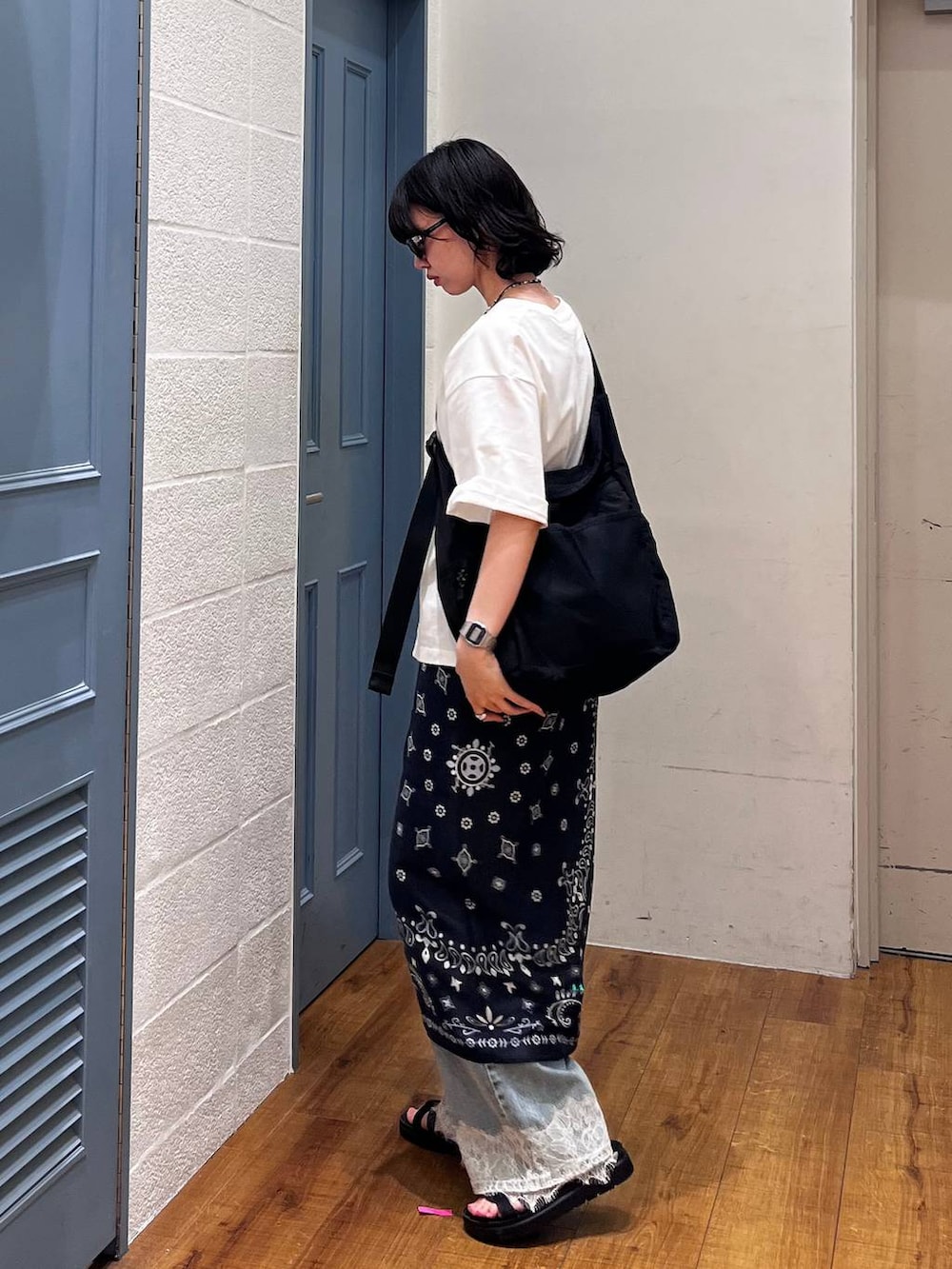 ブラック系のショルダーバッグ、ブルー系のデニムパンツ、ブルー系のバンダナ/スカーフを着用したレディースの夏コーディネートの3枚目の写真