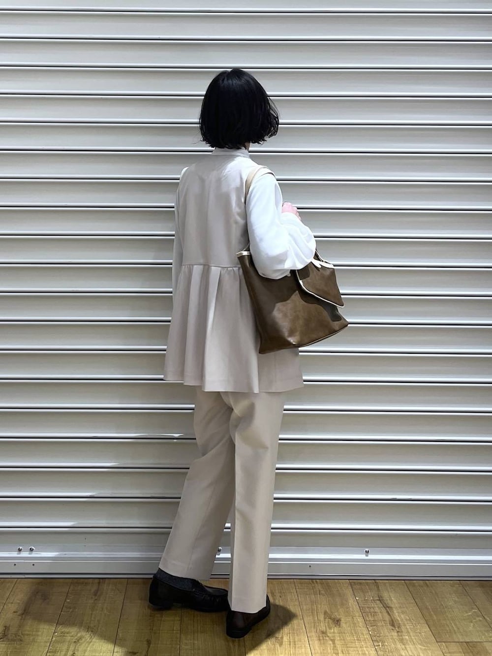 ブラウン系のトートバッグ、ホワイト系のその他パンツ、ホワイト系のベストを着用したレディースの冬コーディネートの3枚目の写真