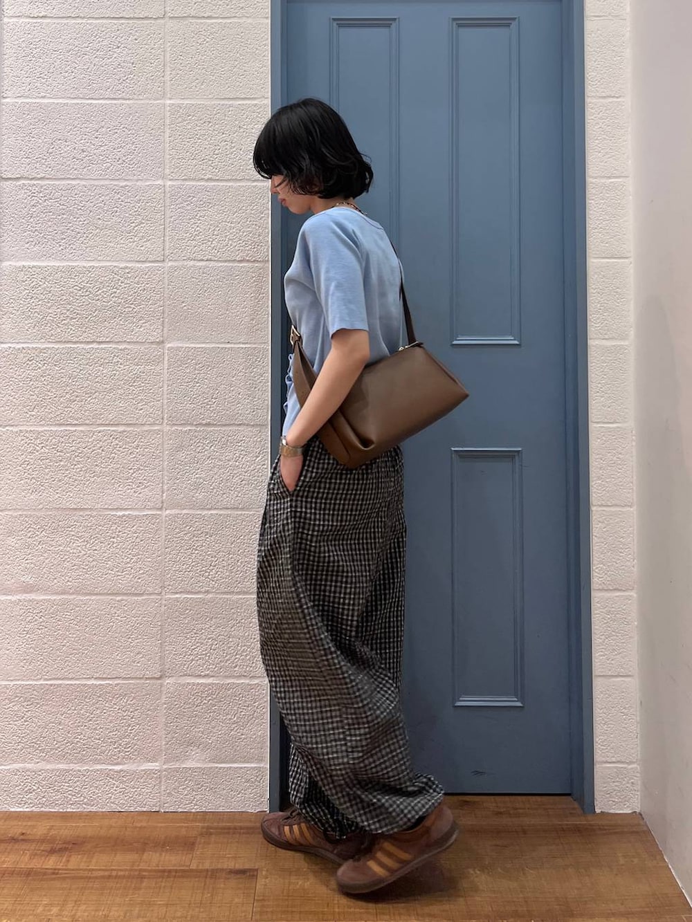 ブラウン系のショルダーバッグ、ブラック系のその他パンツ、ブルー系のカーディガン/ボレロを着用したレディースの春コーディネートの2枚目の写真