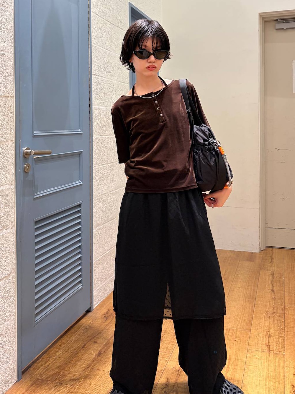 ブラック系のその他パンツ、ブラック系のショルダーバッグ、ブラウン系のTシャツ/カットソーを着用したレディースの夏コーディネートの2枚目の写真