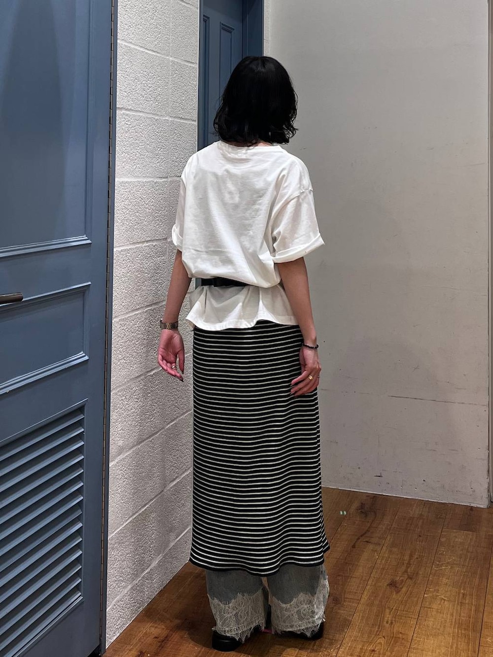 ブルー系のデニムパンツ、ブラック系のボディバッグ/ウエストポーチ、ブラック系のサンダルを着用したレディースの夏コーディネートの3枚目の写真