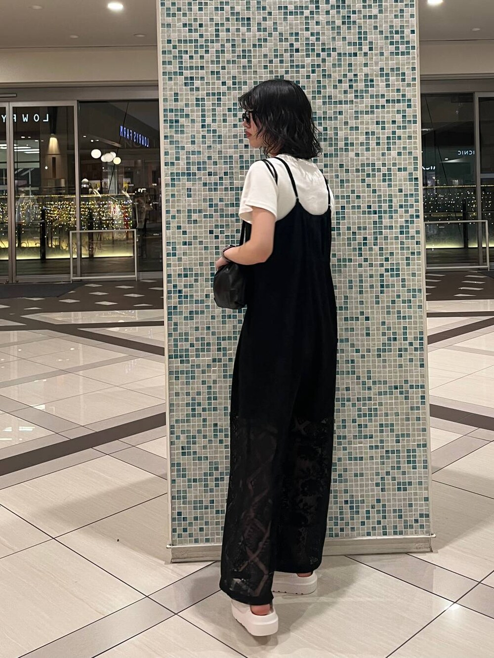 ホワイト系のTシャツ/カットソー、ホワイト系のサンダル、ブラック系のショルダーバッグを着用したレディースの春コーディネートの2枚目の写真