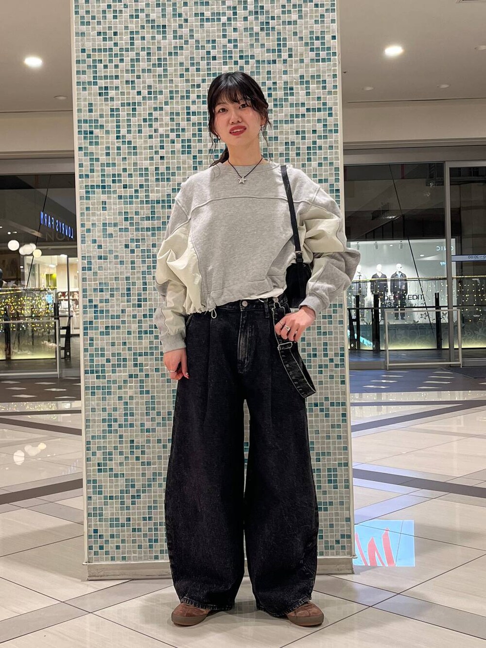 ブラック系のデニムパンツ、ブラック系のトートバッグ、グレー系のスウェットを着用したレディースの春コーディネートの2枚目の写真