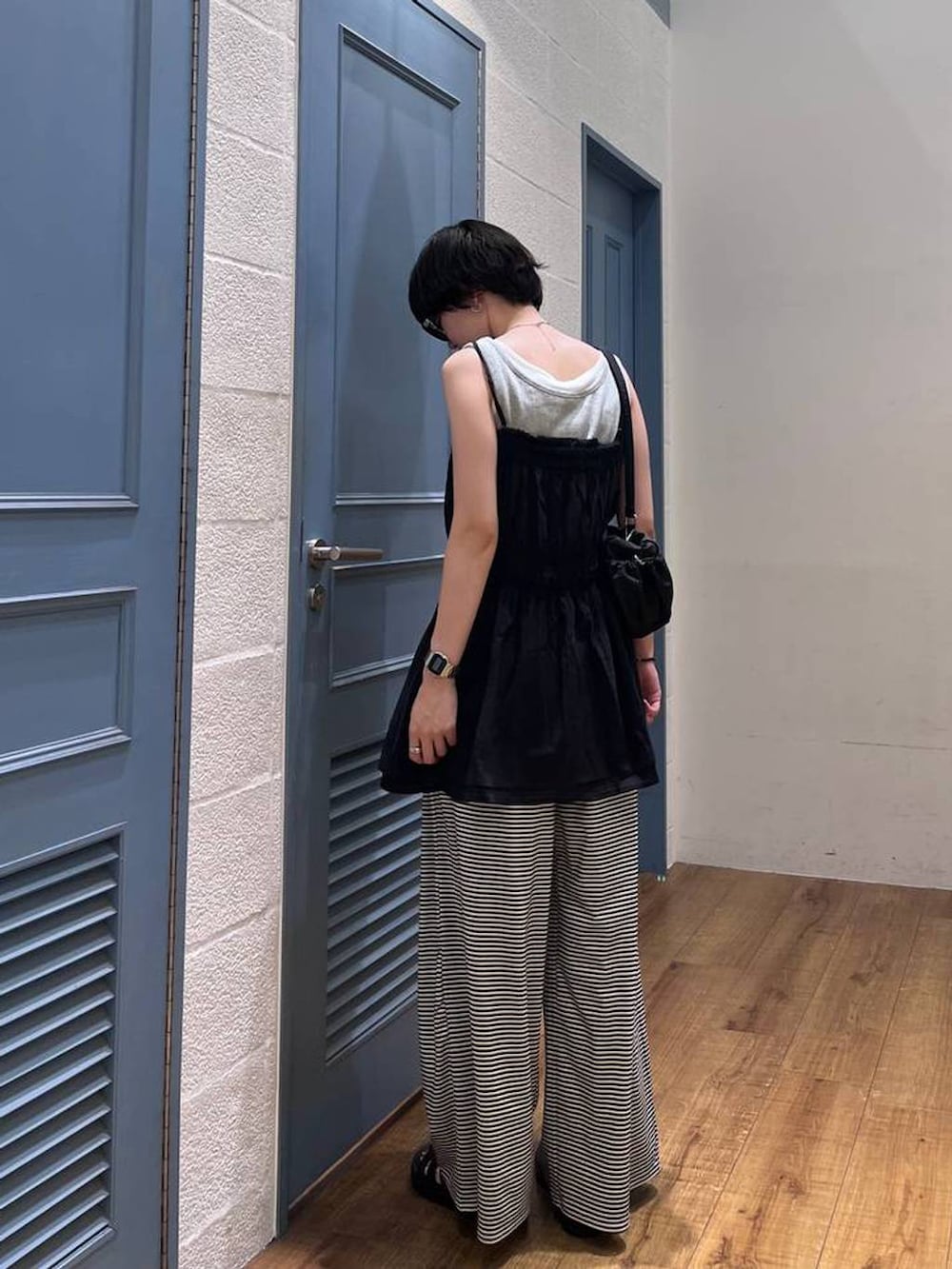 ブラック系のキャミソール、ホワイト系のその他パンツ、ブラック系のサンダルを着用したレディースの夏コーディネートの3枚目の写真