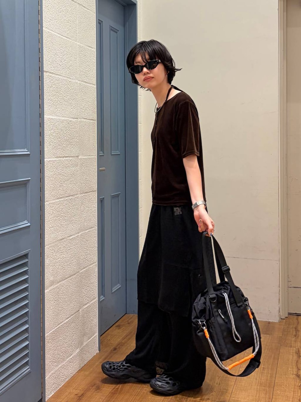 ブラック系のその他パンツ、ブラック系のショルダーバッグ、ブラウン系のTシャツ/カットソーを着用したレディースの夏コーディネートの3枚目の写真