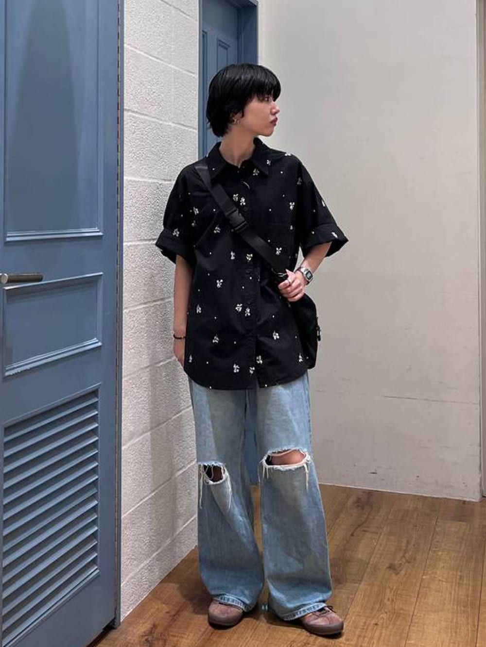 ブラック系のショルダーバッグ、ブルー系のデニムパンツ、ブラック系のシャツ/ブラウスを着用したレディースの夏コーディネートの3枚目の写真
