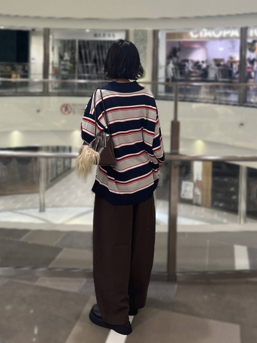 ブラック系のサンダル、ブルー系のニット/セーター、ブラウン系のボストンバッグを着用したレディースの秋コーディネートの3枚目の写真