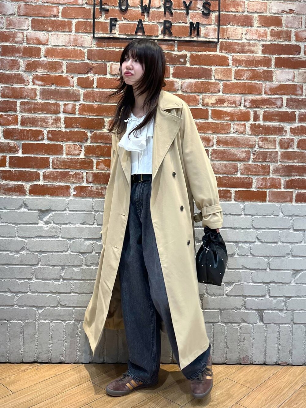 ホワイト系のシャツ/ブラウス、ブラック系のデニムパンツ、ホワイト系のトレンチコートを着用したレディースの春コーディネートの2枚目の写真