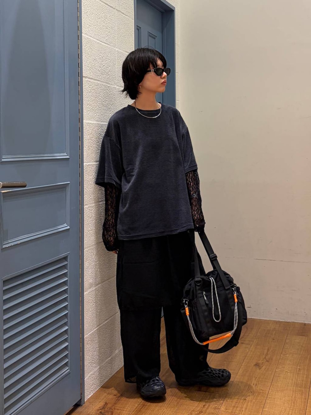 ブラック系のその他パンツ、ブラック系のショルダーバッグ、グリーン系のTシャツ/カットソーを着用したレディースの夏コーディネートの3枚目の写真