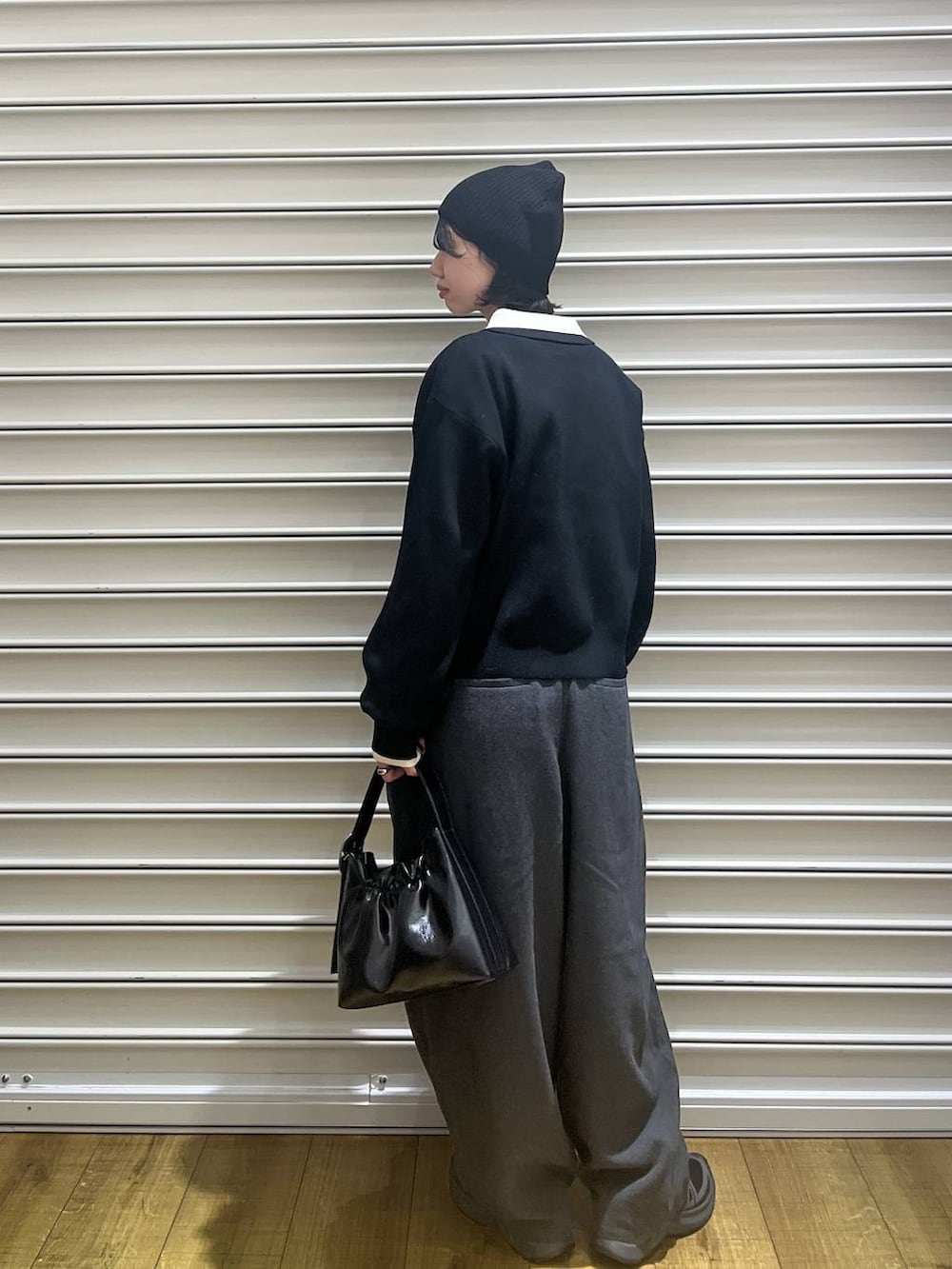 ブラック系のショルダーバッグ、ブラック系のニット/セーター、ブラック系のニットキャップ/ビーニーを着用したレディースの冬コーディネートの3枚目の写真