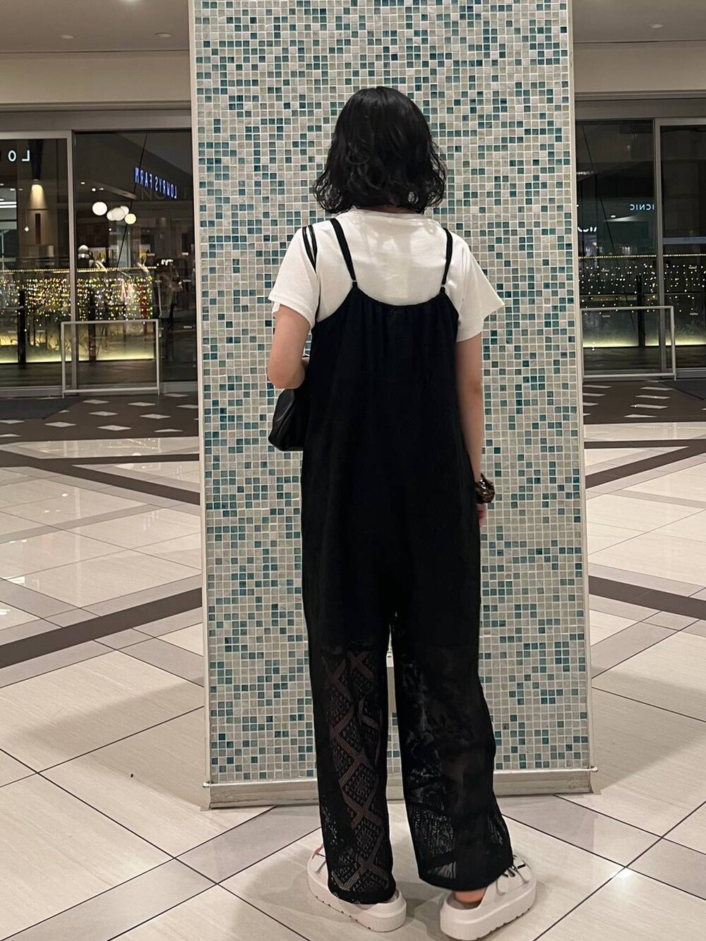 ホワイト系のTシャツ/カットソー、ホワイト系のサンダル、ブラック系のショルダーバッグを着用したレディースの春コーディネートの3枚目の写真