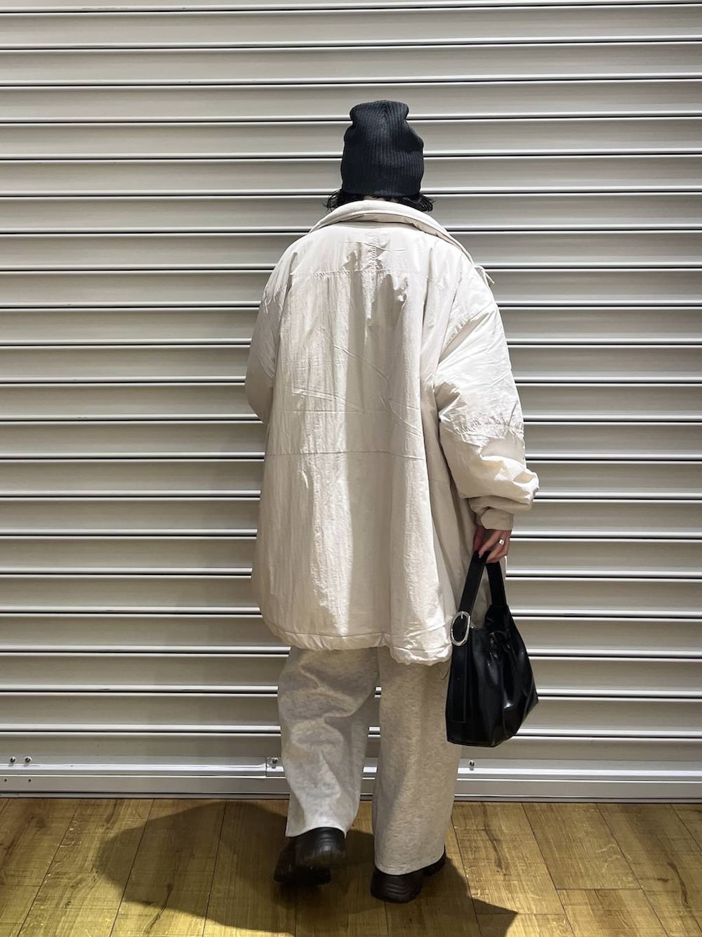 ブラック系のブーツ、グレー系のスウェットパンツ、ブラック系のショルダーバッグを着用したレディースの秋コーディネートの5枚目の写真