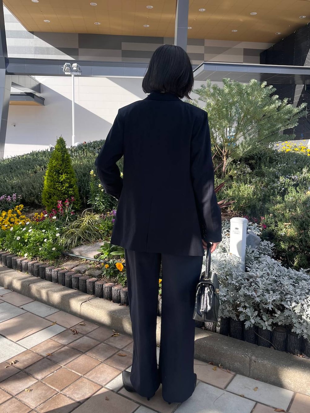 ブラック系のボストンバッグ、ブラック系のブーツ、ホワイト系のシャツ/ブラウスを着用したレディースの冬コーディネートの3枚目の写真