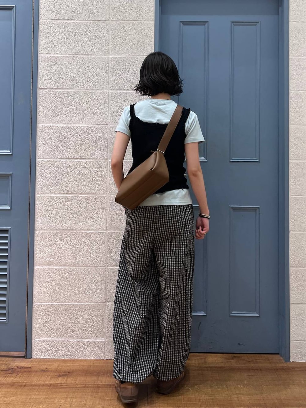 ブラック系のタンクトップ、ブラウン系のショルダーバッグ、ブルー系のTシャツ/カットソーを着用したレディースの春コーディネートの3枚目の写真