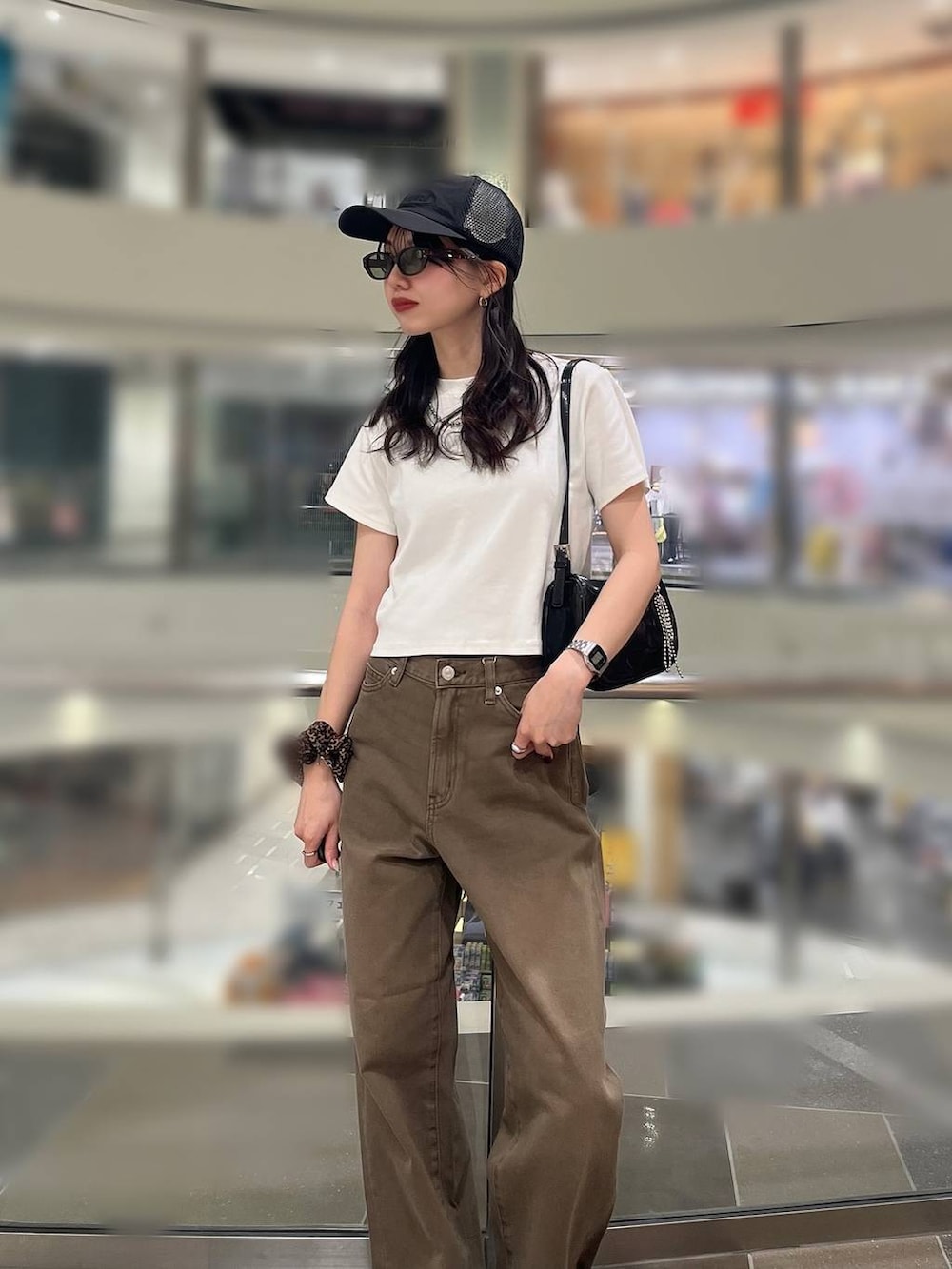 ホワイト系のTシャツ/カットソー、ブラック系のトートバッグ、ブラウン系のデニムパンツを着用したレディースの春コーディネートの2枚目の写真