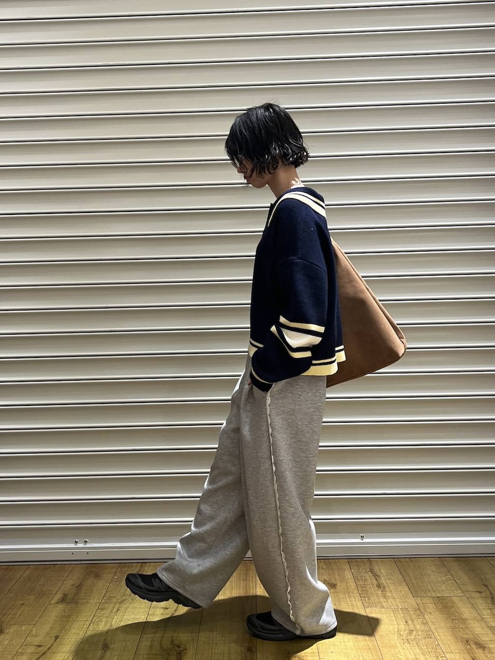 ベージュ系のショルダーバッグ、グレー系のスウェットパンツ、ブルー系のニット/セーターを着用したレディースの冬コーディネートの2枚目の写真