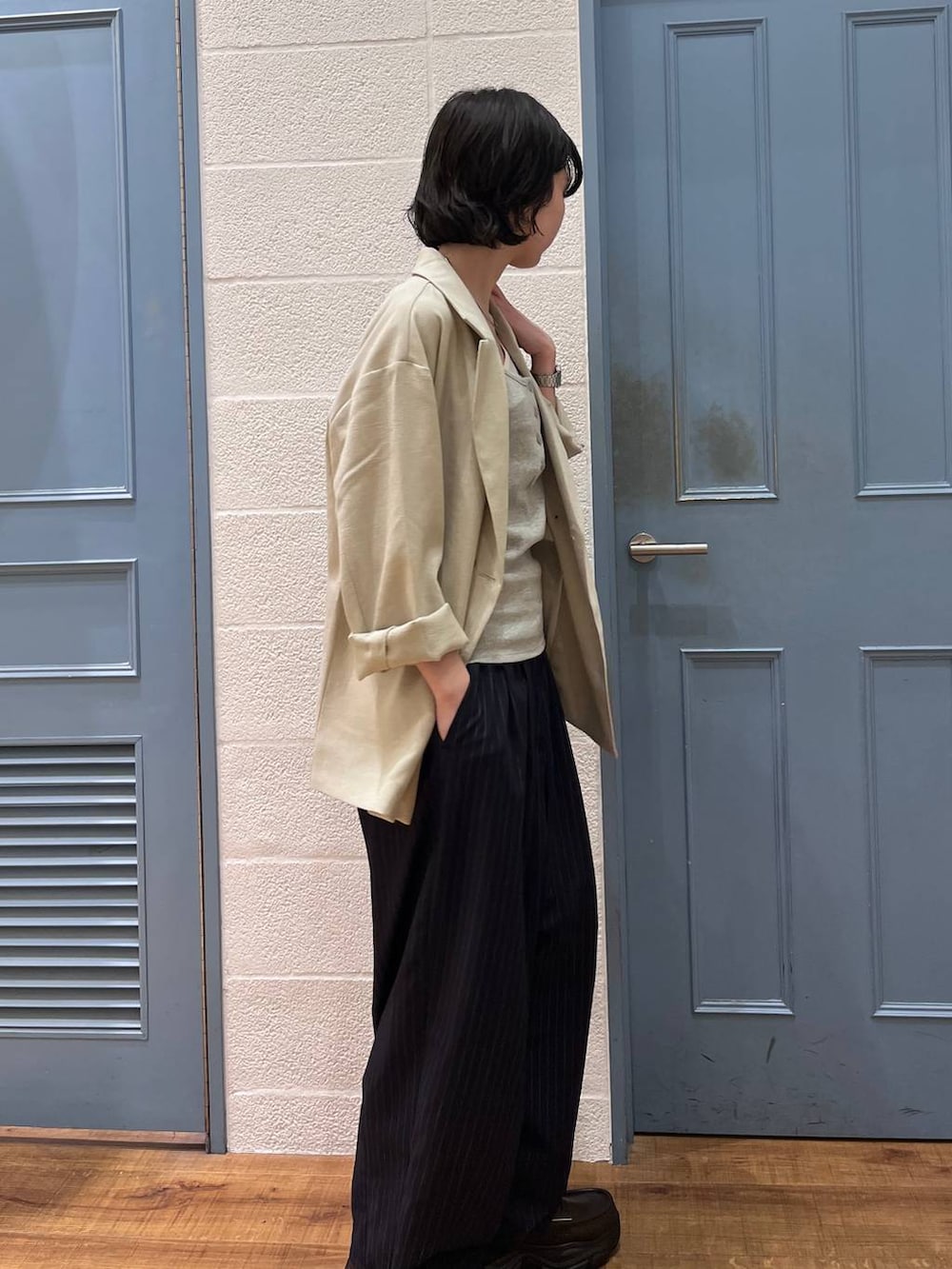 ブルー系のその他パンツ、ベージュ系のその他アウター、ブラウン系のショルダーバッグを着用したレディースの春コーディネートの3枚目の写真