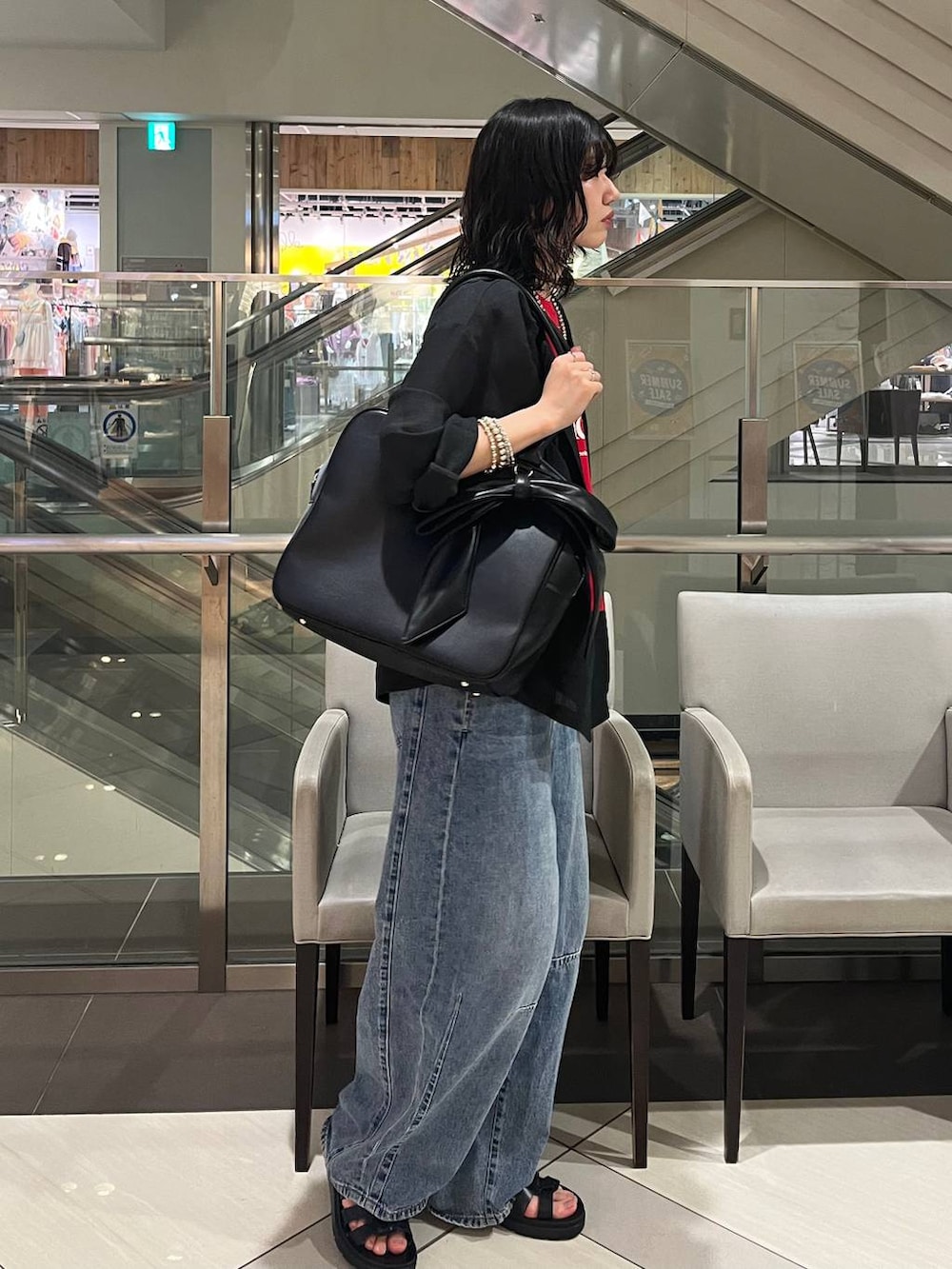 ブラック系のサンダル、ブルー系のデニムパンツ、レッド系のTシャツ/カットソーを着用したレディースの夏コーディネートの4枚目の写真