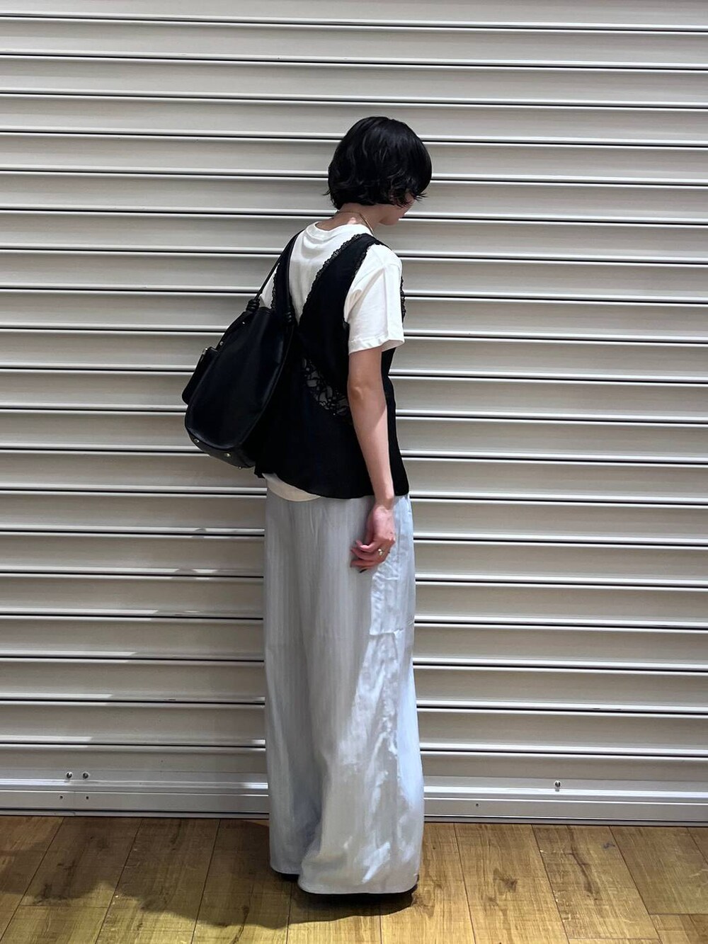 ブラック系のローファー、ホワイト系のTシャツ/カットソー、ブラック系のベストを着用したレディースの春コーディネートの2枚目の写真