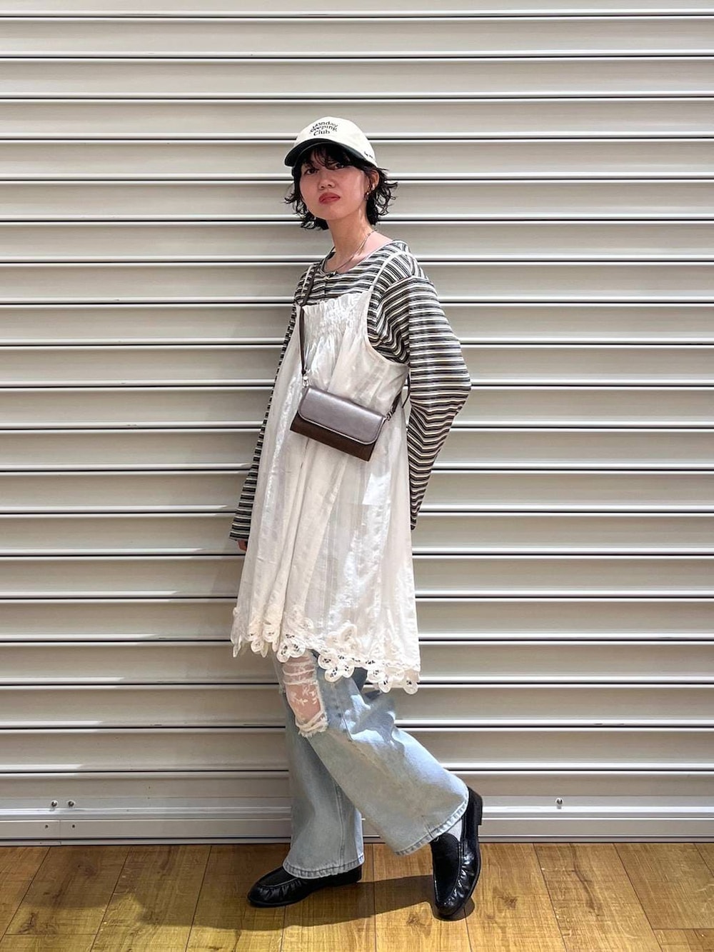 ブルー系のデニムパンツ、ブラック系のローファー、ブラウン系のボディバッグ/ウエストポーチを着用したレディースの春コーディネートの2枚目の写真