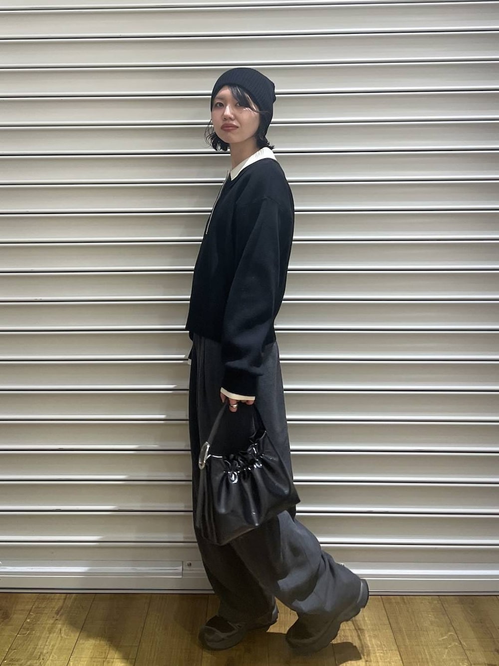 ブラック系のショルダーバッグ、ブラック系のニット/セーター、ブラック系のニットキャップ/ビーニーを着用したレディースの冬コーディネートの2枚目の写真