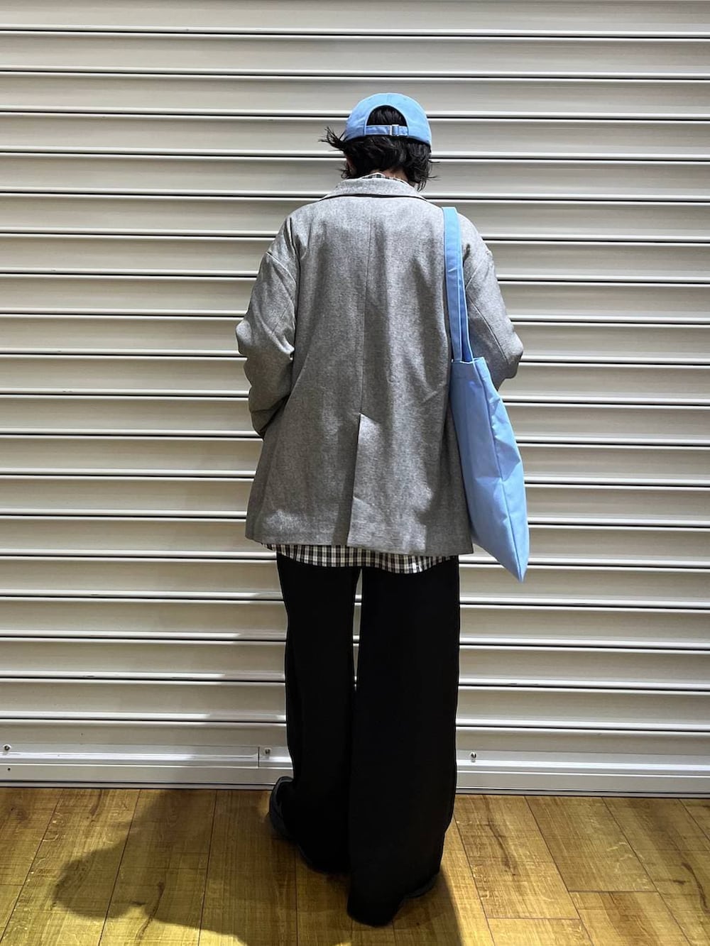 ブラック系のその他パンツ、グレー系のテーラードジャケット、ブルー系のトートバッグを着用したレディースの春コーディネートの4枚目の写真