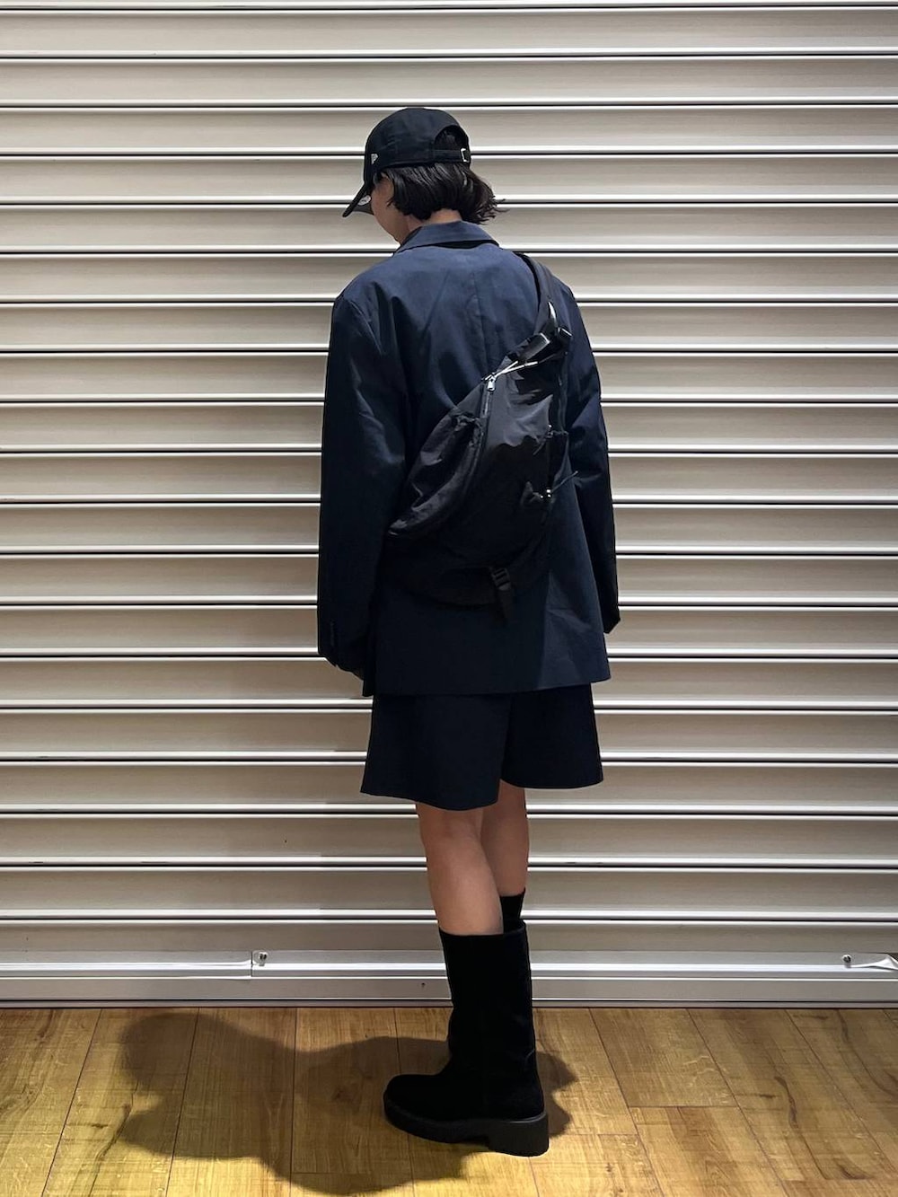 ブラック系のブーツ、ブラック系のショルダーバッグ、ブルー系のTシャツ/カットソーを着用したレディースの冬コーディネートの3枚目の写真