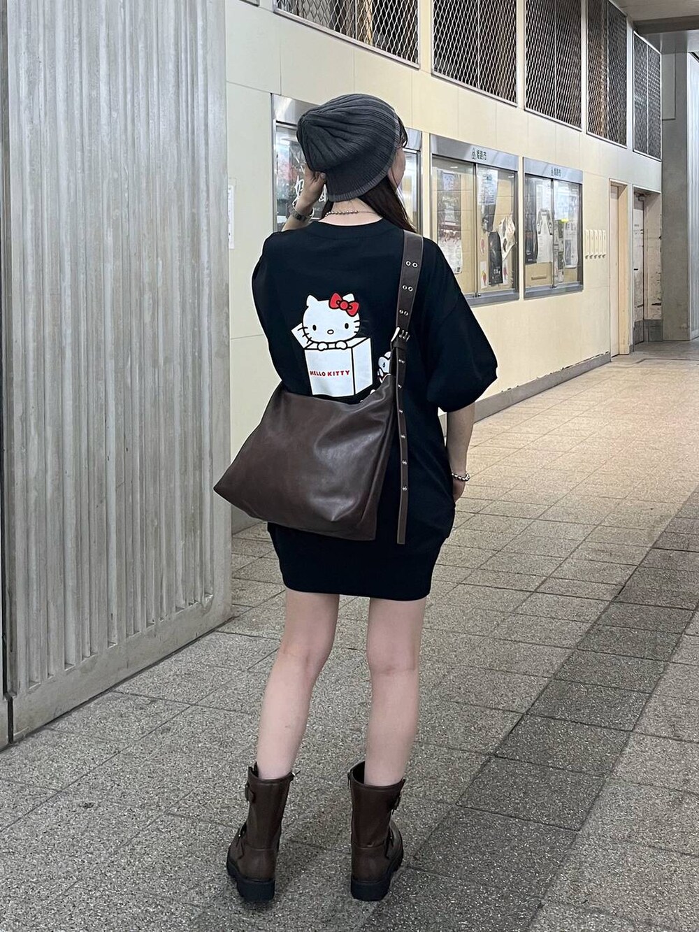 ブラウン系のボディバッグ/ウエストポーチ、ブラウン系のブーツ、ブラック系のラッシュガードを着用したレディースの夏コーディネートの2枚目の写真